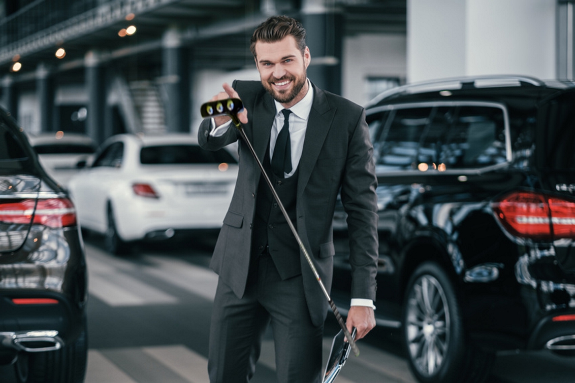 car salesman holding a golf putter